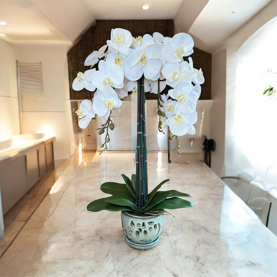 Artificial white orchid arrangement in a decorative ceramic planter for home decor
