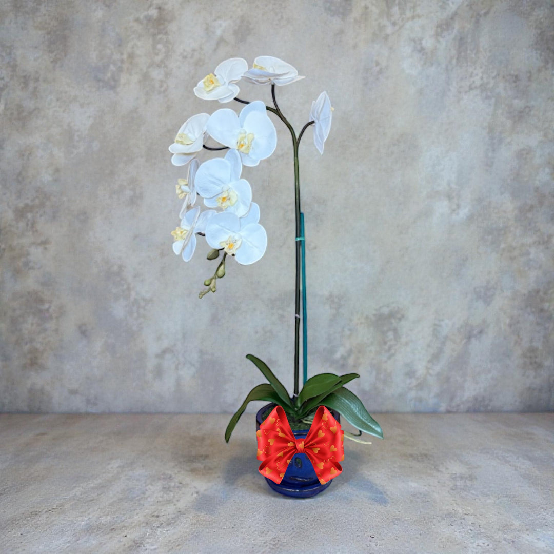 Artificial white orchid flowers in a blue ceramic pot with realistic blooms
