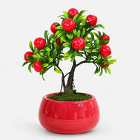 Artificial mini apple bonsai in a red ceramic planter.