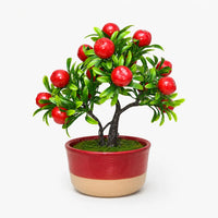 Artificial mini apple bonsai in a red and beige ceramic planter.